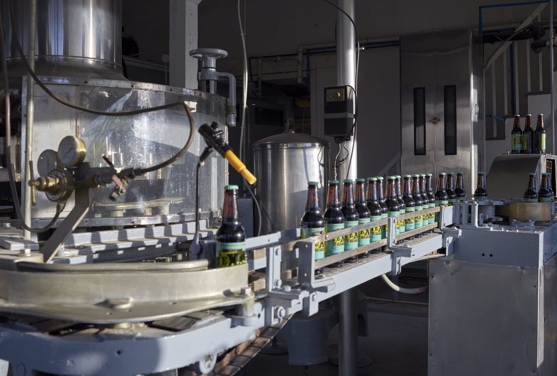 Línea de lavado y llenado de botellas en operación dentro de una planta embotelladora