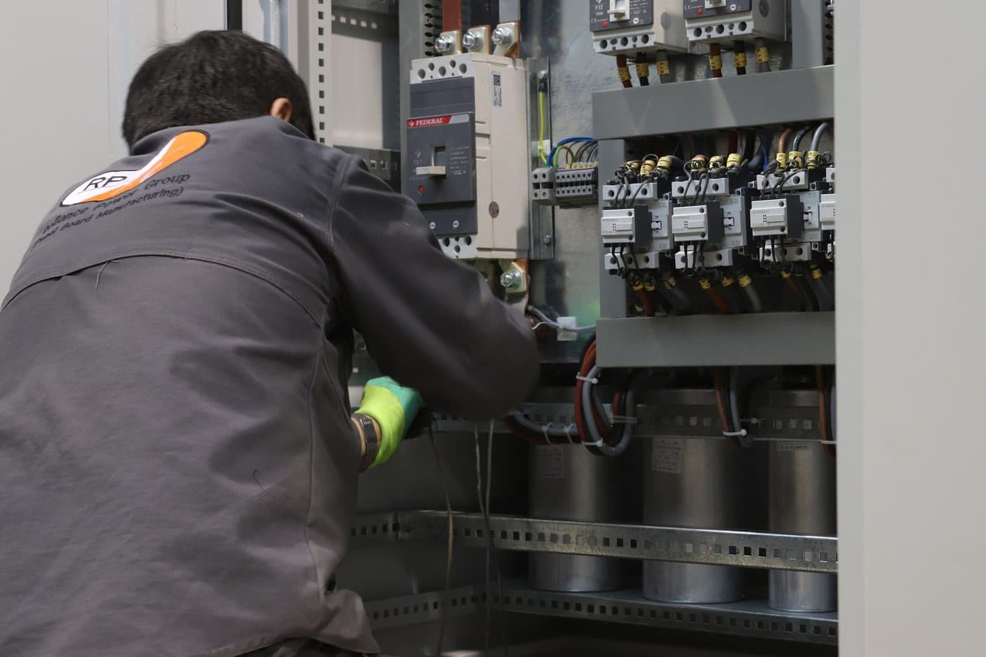 Técnico conectando el cableado de fuerza dentro de un tablero de control